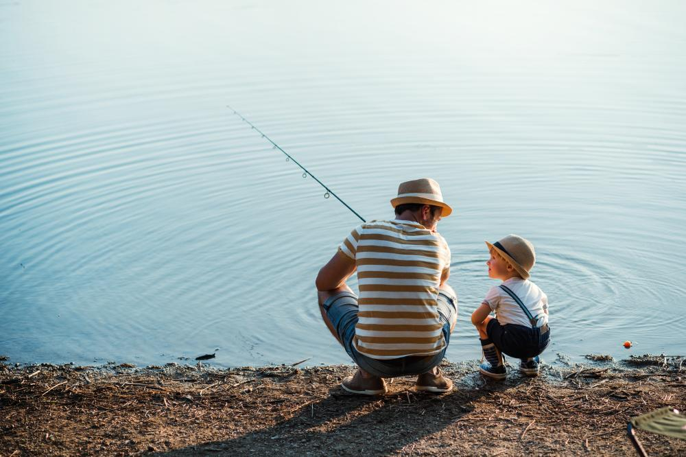 man and boy fishing on shore adobestock 258927106