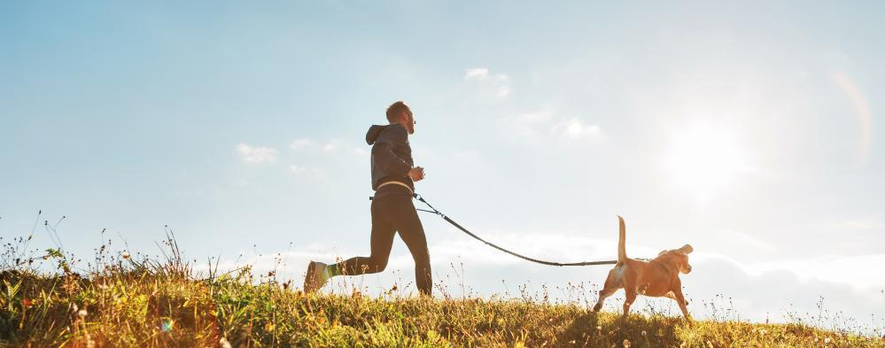 man running with dog as
