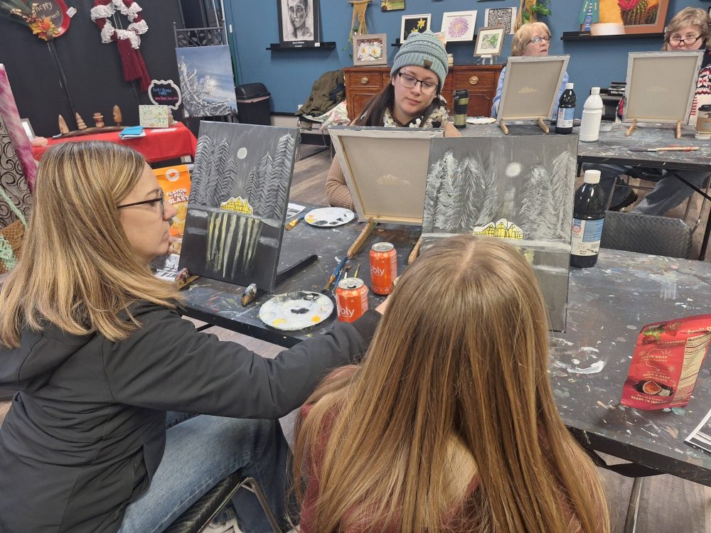 a group of women painting on canvas